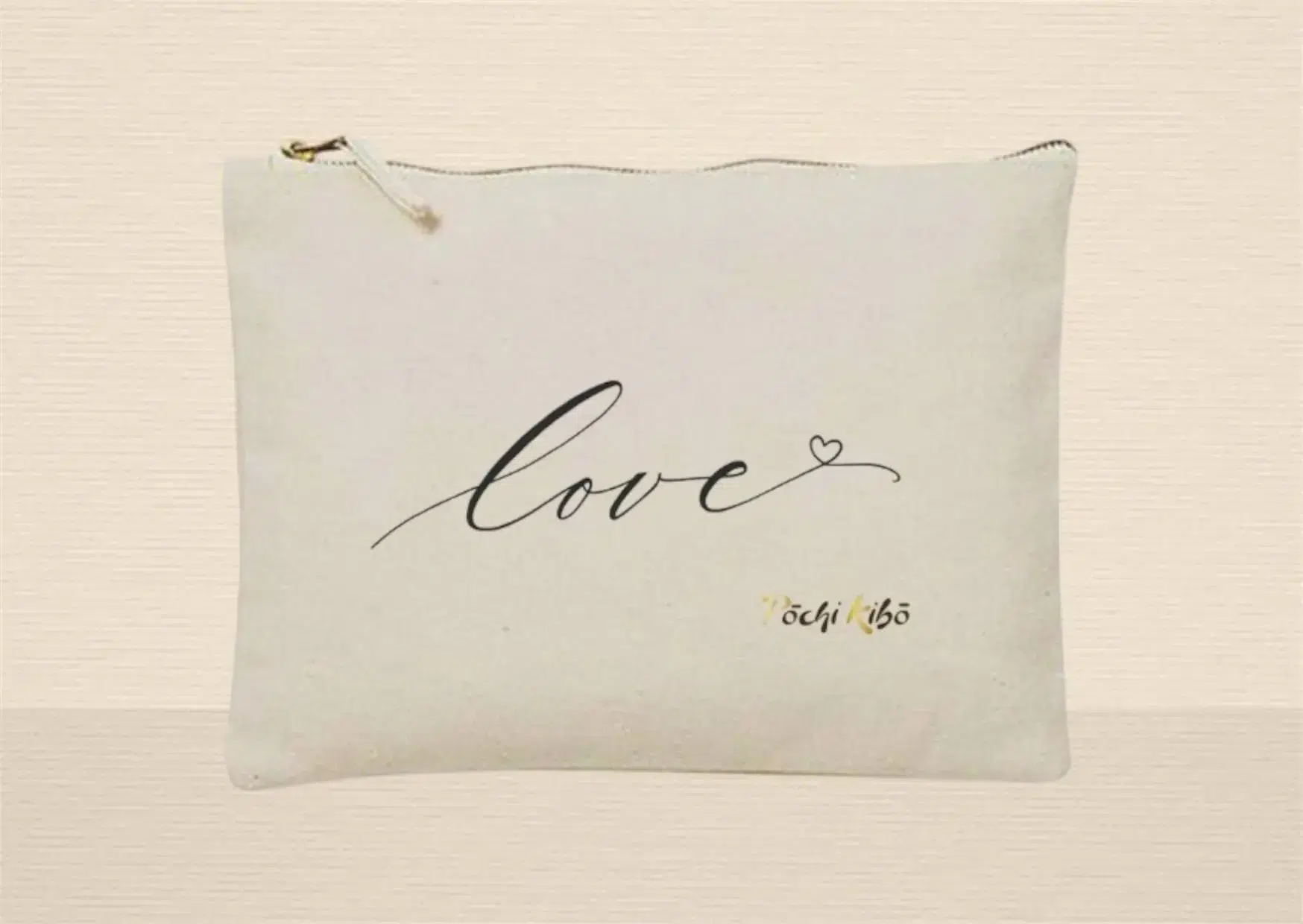 Pochette Pochi Love beige photographiée de face sur fond beige, tracé représentant le mot "Love" se terminant par un cœur, logo Pochi Kibo en bas à droite. Pochettes d’accompagnement et de soutien.