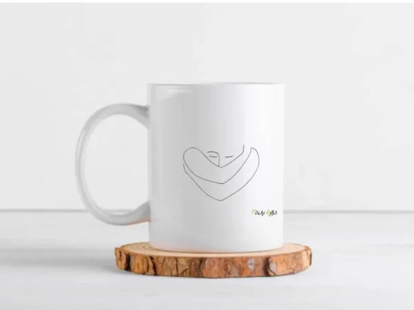 Mug Confiance en soi Pochi Kibo, blanc à l’extérieur et noir à l’intérieur, vu de face, tracé représentant une personne qui se prend dans ses bras, logo Pochi Kibo en bas à droite, posé sur un morceau de bois rond sur une table, fond blanc