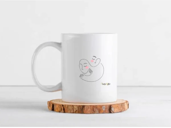 Mug Réconfort Pochi Kibo, blanc à l’extérieur et noir à l’intérieur, vu de face, tracé représentant deux personnes qui se réconfortent en s’enlaçant, logo Pochi Kibo en bas à droite, posé sur un morceau de bois rond sur une table, fond blanc.
